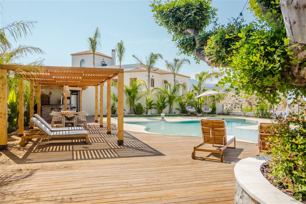 Terras met zwembad en palmbomen bij een Griekse woning